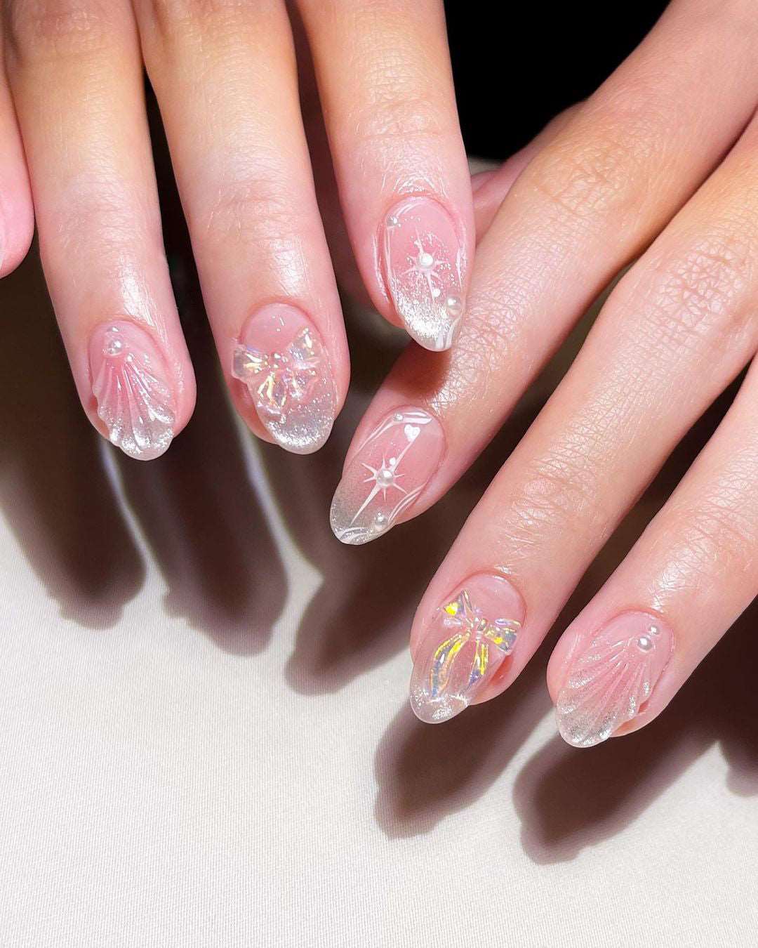 Clear seashell nail design with pearl and shell decorations