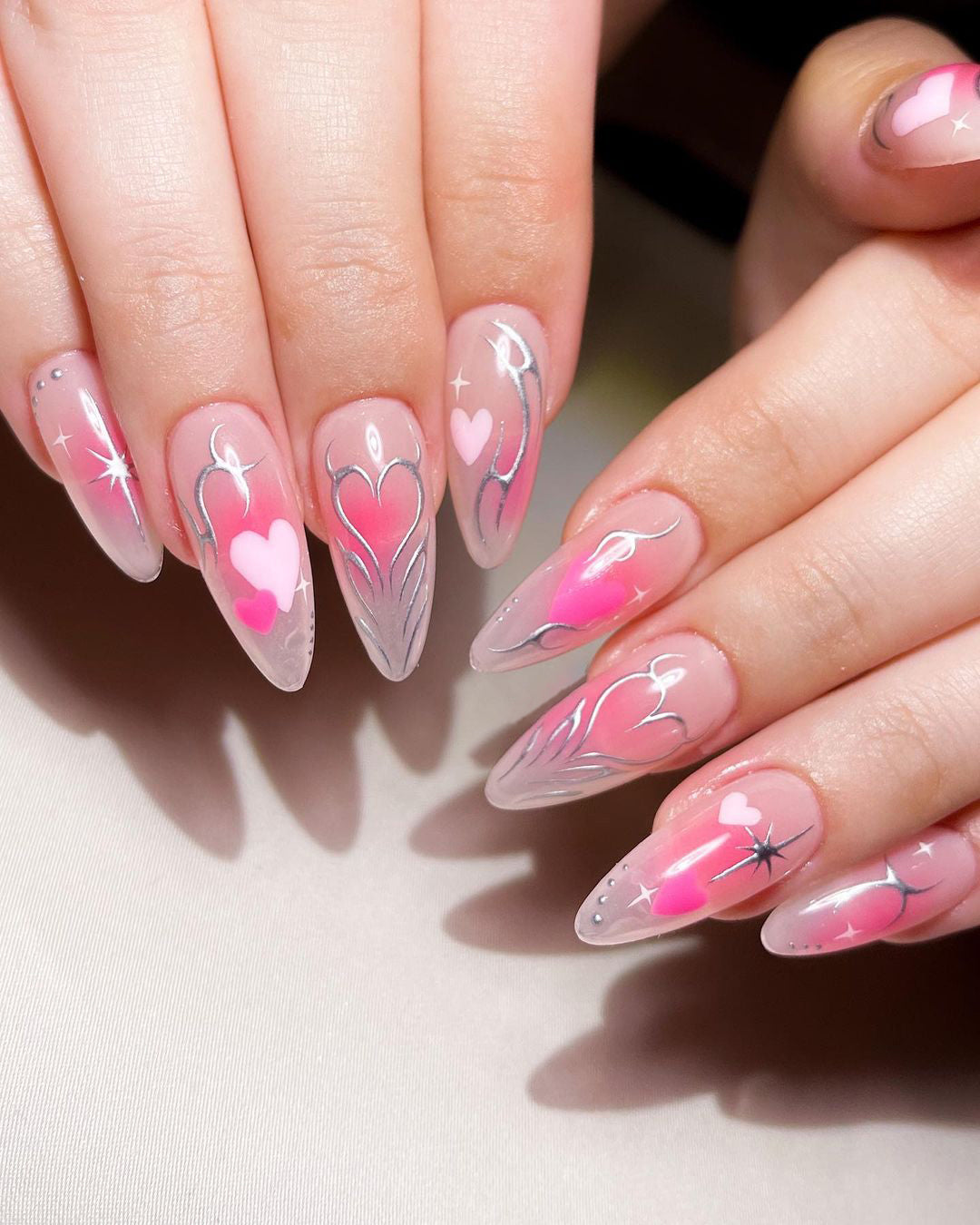 Pink press-on nail design with red hearts